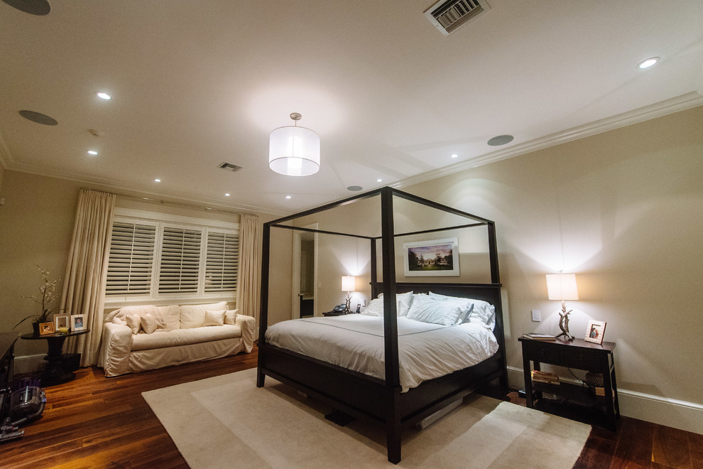 Imagen de dormitorio principal contemporáneo de tamaño medio sin chimenea con paredes beige, suelo de madera en tonos medios y suelo beige