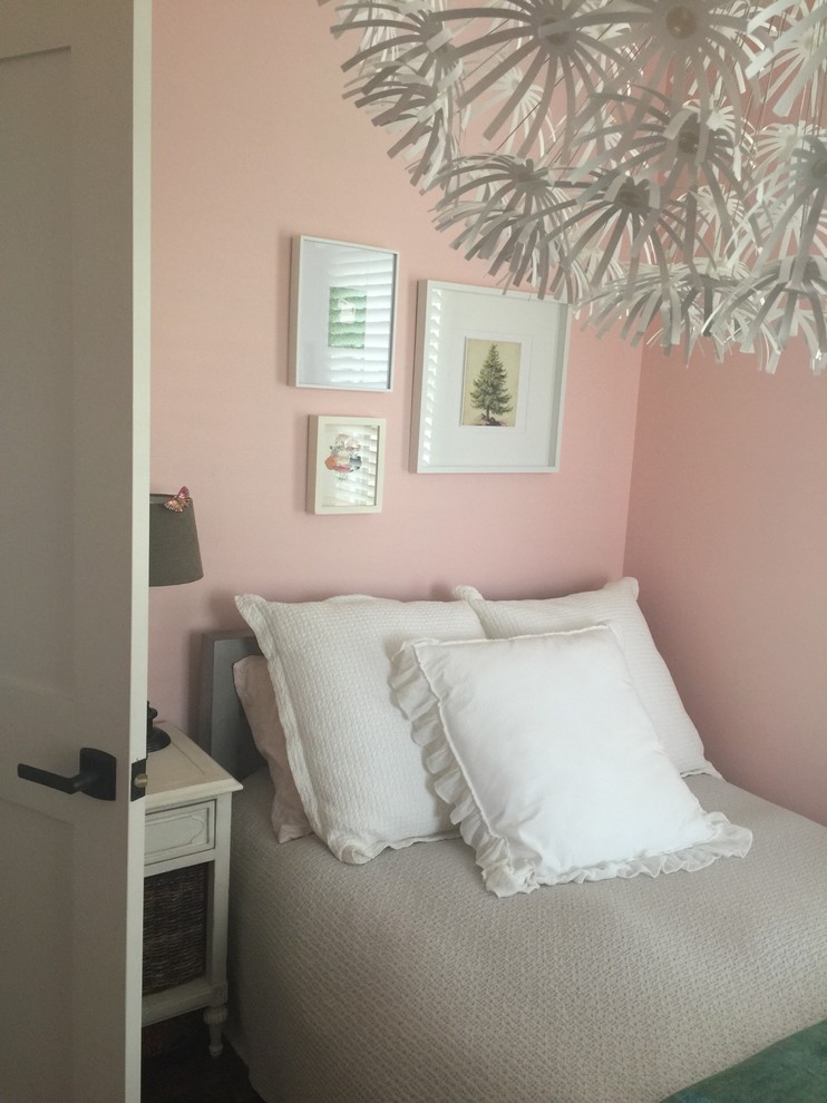 Modelo de habitación de invitados pequeña sin chimenea con paredes rosas y suelo de madera en tonos medios