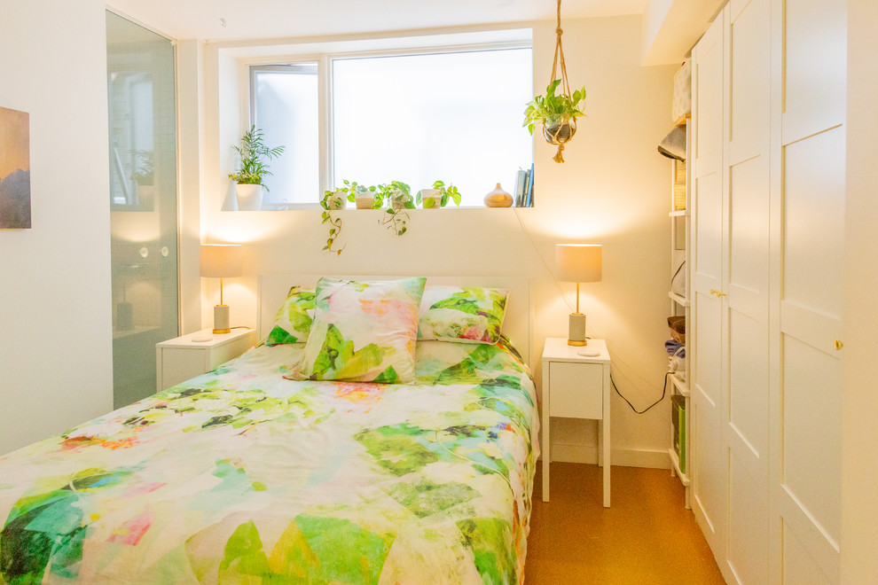 Foto de dormitorio principal actual pequeño con paredes blancas y suelo de contrachapado