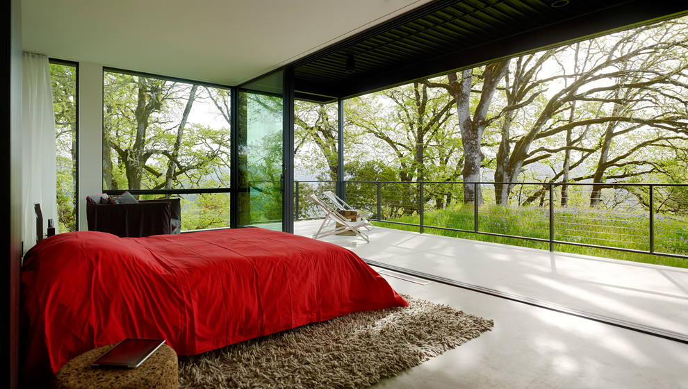 Cette image montre une chambre parentale minimaliste avec sol en béton ciré, aucune cheminée, un mur beige et un sol gris.