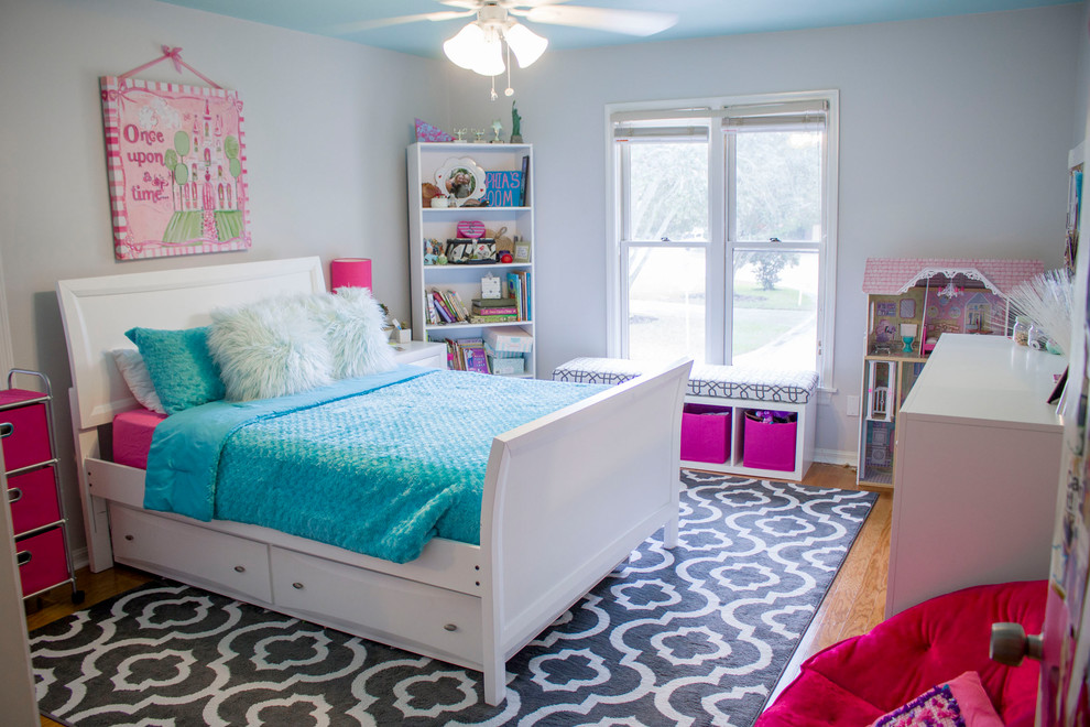 Foto di una camera da letto design con pareti grigie e parquet chiaro