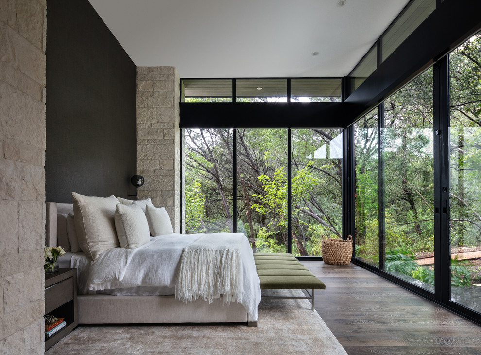 Idées déco pour une chambre parentale contemporaine avec un mur noir, parquet foncé, aucune cheminée et un sol marron.