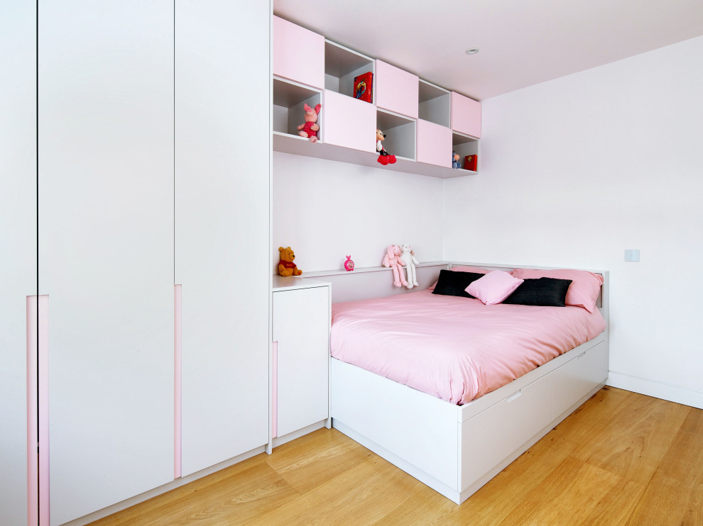 Inspiration for a medium sized modern guest and grey and pink bedroom in London with grey walls, medium hardwood flooring and brown floors.