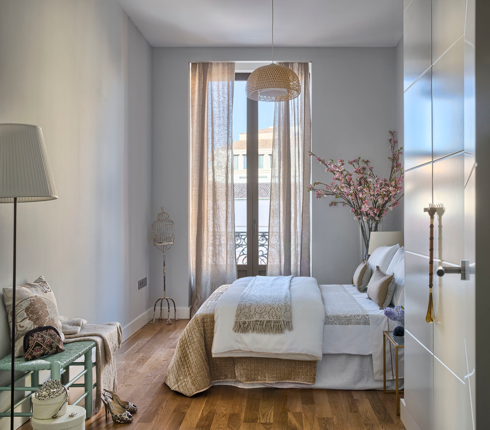 На фото: хозяйская спальня среднего размера в стиле фьюжн с светлым паркетным полом, серыми стенами и тюлем без камина