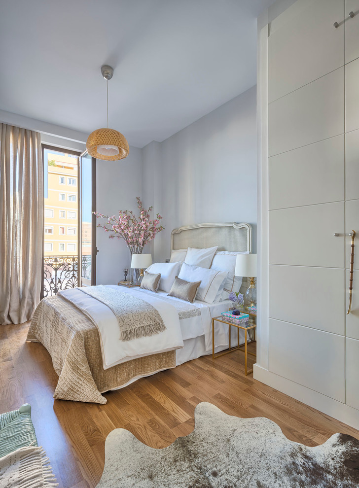 На фото: хозяйская спальня среднего размера в стиле неоклассика (современная классика) с синими стенами и паркетным полом среднего тона без камина