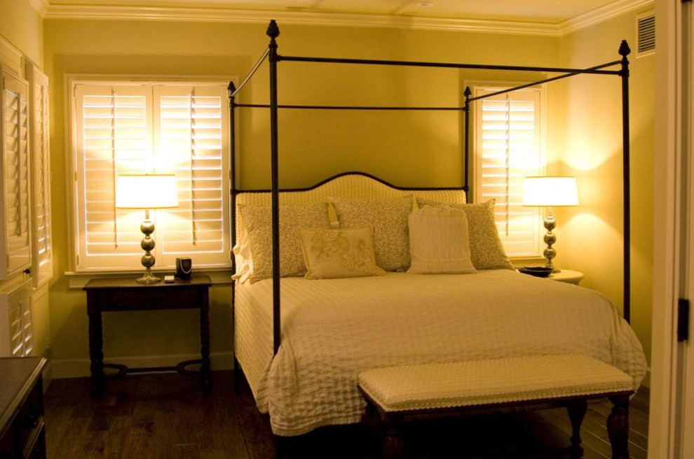 Diseño de habitación de invitados costera de tamaño medio sin chimenea con paredes beige, suelo de madera oscura y suelo marrón