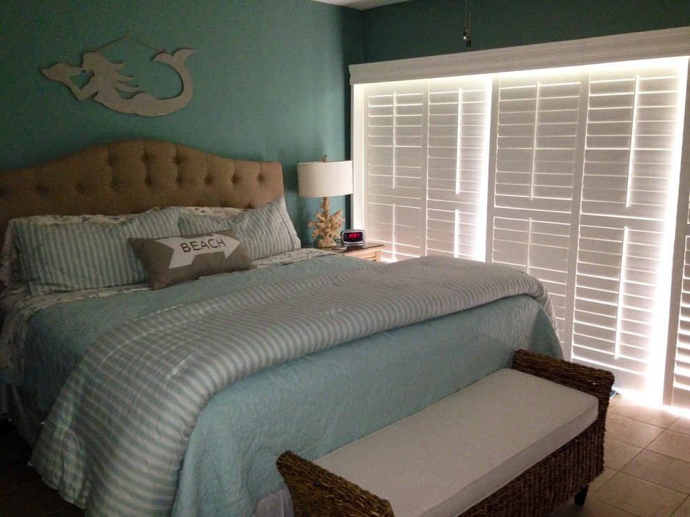 Ejemplo de dormitorio principal costero de tamaño medio sin chimenea con paredes verdes, suelo de baldosas de cerámica y suelo beige