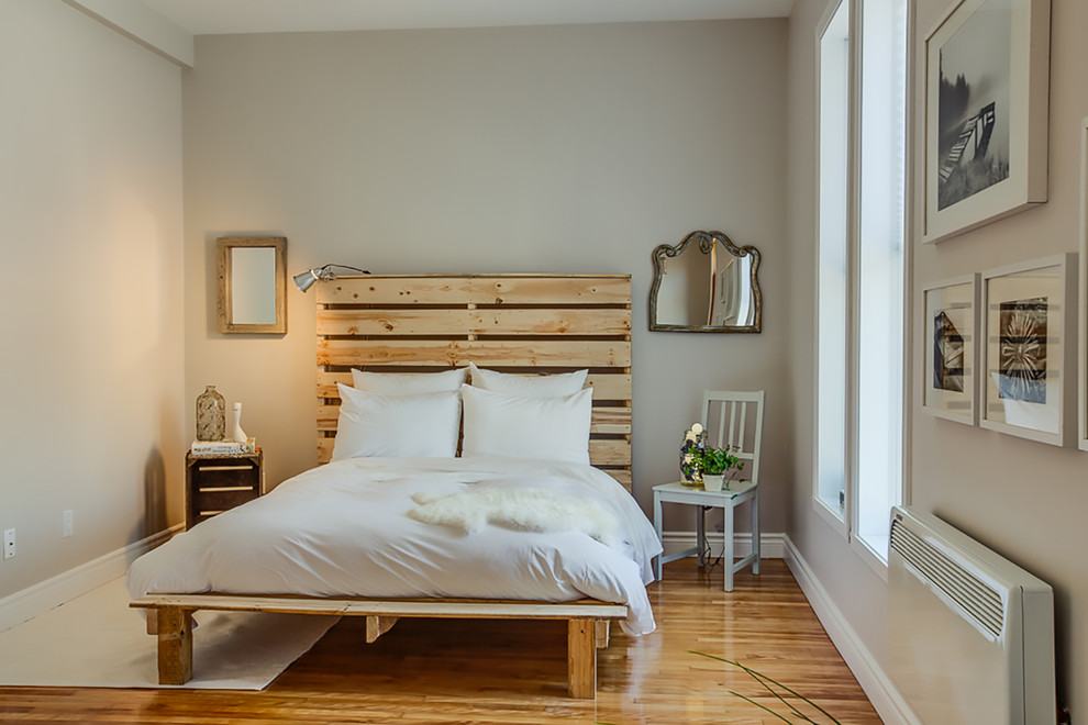 Eklektisk inredning av ett litet sovrum, med grå väggar och mellanmörkt trägolv