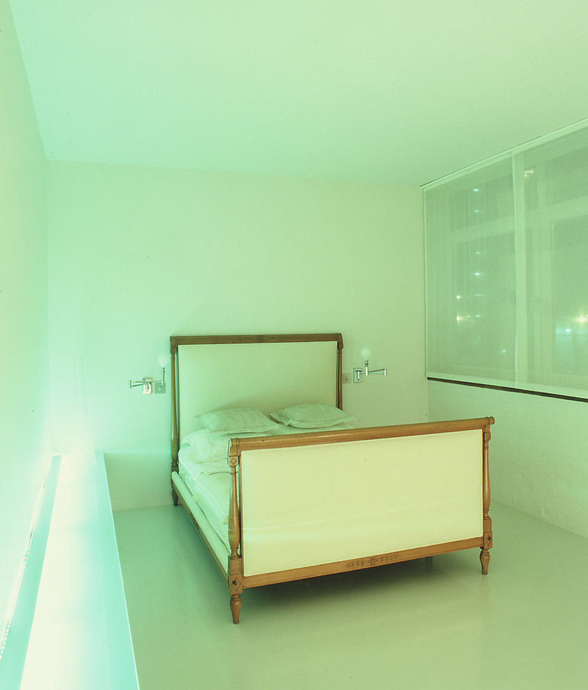 Imagen de dormitorio principal minimalista de tamaño medio con paredes blancas, suelo vinílico y suelo blanco