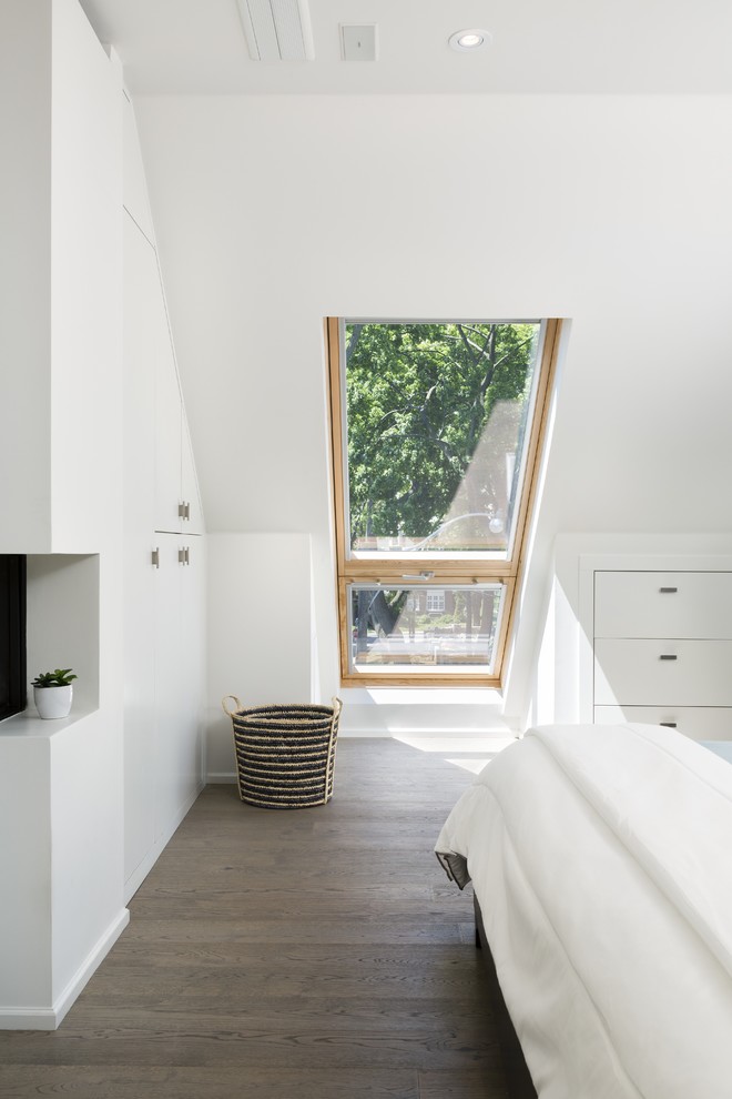 Ejemplo de dormitorio principal actual grande con paredes blancas y suelo de madera en tonos medios