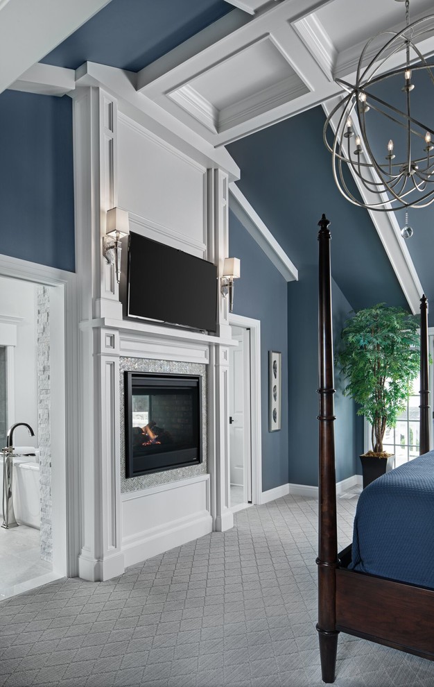 На фото: большая хозяйская спальня в классическом стиле с синими стенами, ковровым покрытием, печью-буржуйкой, фасадом камина из плитки и серым полом с