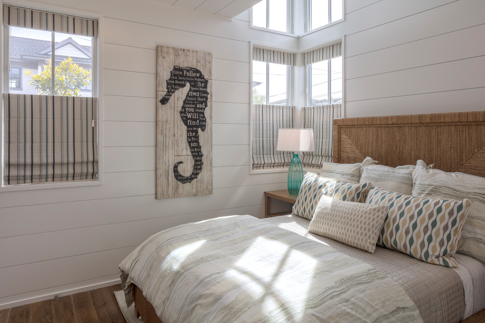 Ejemplo de habitación de invitados marinera pequeña con paredes blancas y suelo de madera en tonos medios