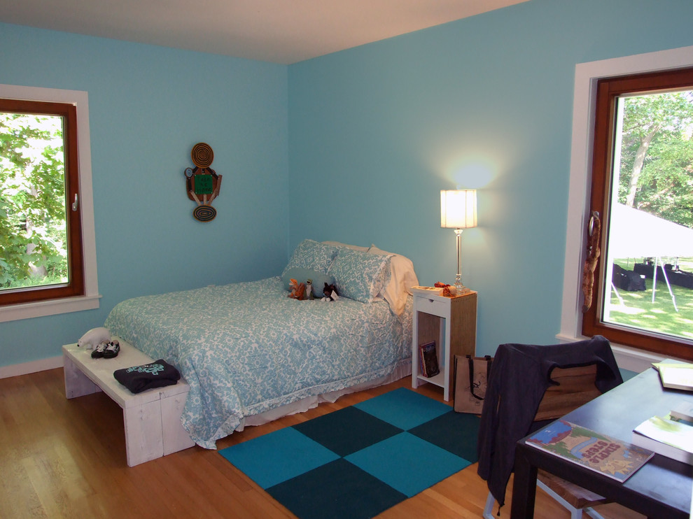Réalisation d'une petite chambre d'amis design avec un mur bleu, parquet clair, aucune cheminée et un sol bleu.