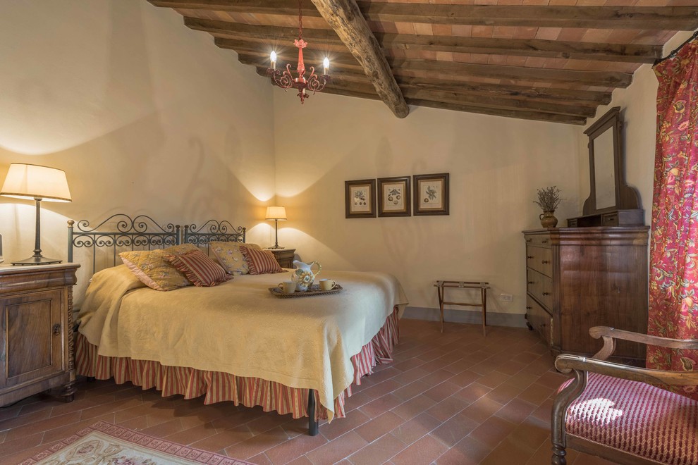 Großes Landhaus Hauptschlafzimmer mit weißer Wandfarbe und Terrakottaboden in Florenz