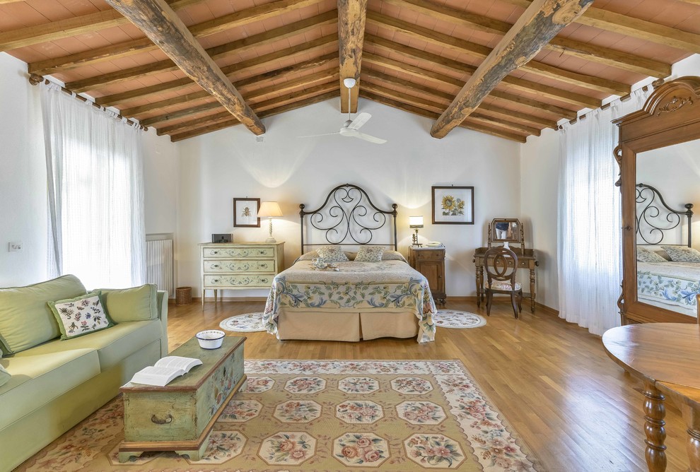 Großes Country Hauptschlafzimmer mit weißer Wandfarbe und braunem Holzboden in Florenz