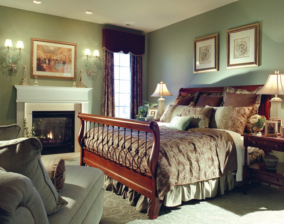 На фото: хозяйская спальня среднего размера в классическом стиле с зелеными стенами, ковровым покрытием, стандартным камином и фасадом камина из штукатурки