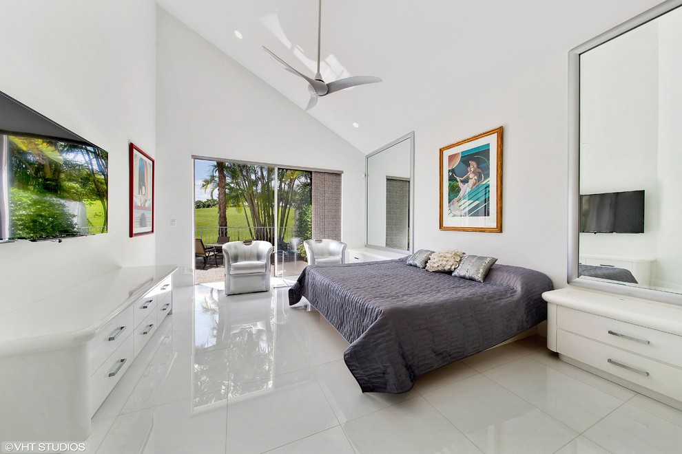This is an example of a contemporary master bedroom in Miami with white walls and porcelain flooring.