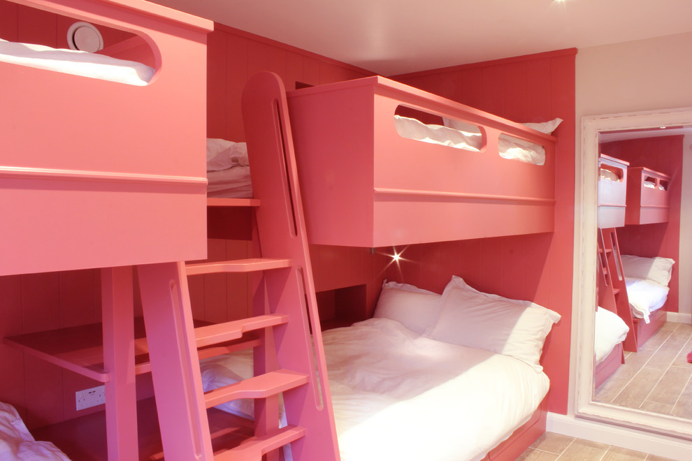 コーンウォールにある広い北欧スタイルのおしゃれな客用寝室 (赤い壁、磁器タイルの床、ベージュの床)