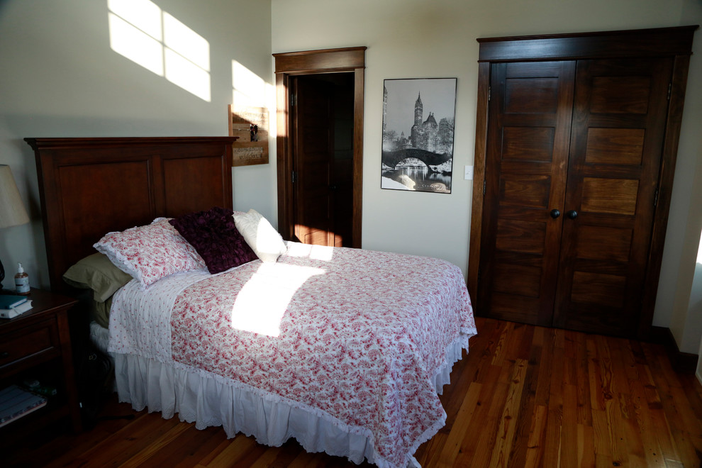 他の地域にあるカントリー風のおしゃれな客用寝室 (無垢フローリング、ベージュの床) のインテリア