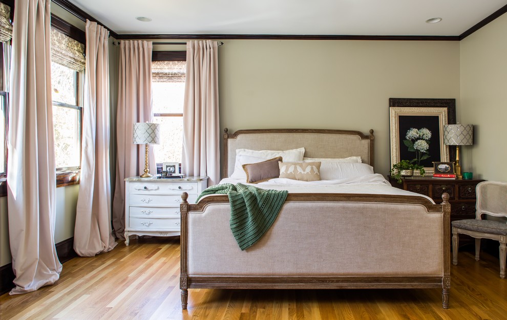 Modelo de dormitorio principal tradicional sin chimenea con suelo de madera en tonos medios y paredes grises