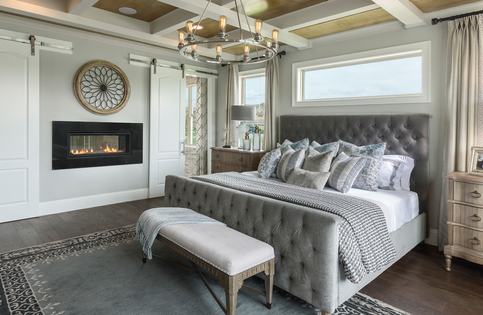 Идея дизайна: хозяйская спальня в классическом стиле с серыми стенами, темным паркетным полом, горизонтальным камином и коричневым полом