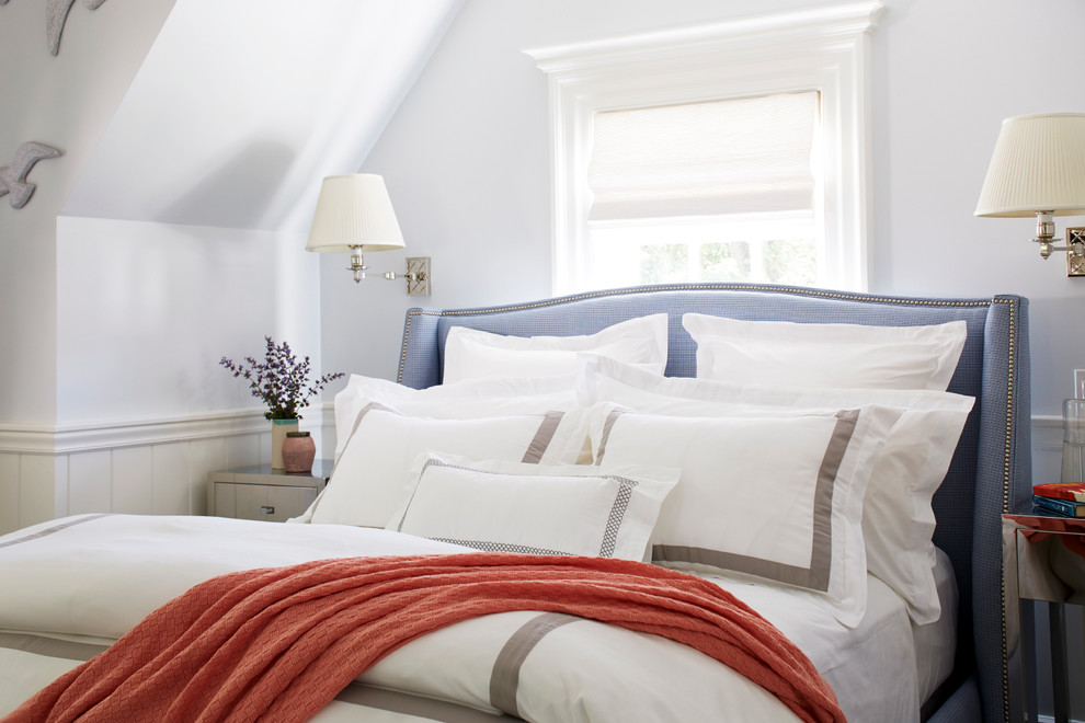 This is an example of a coastal guest bedroom in New York with blue walls.