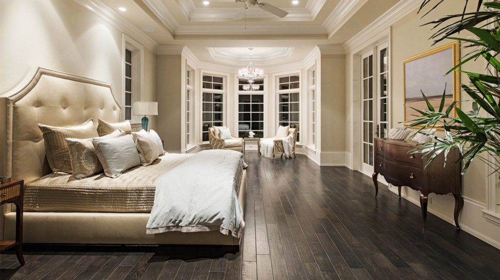 Design ideas for a large traditional master bedroom in Miami with beige walls and dark hardwood flooring.