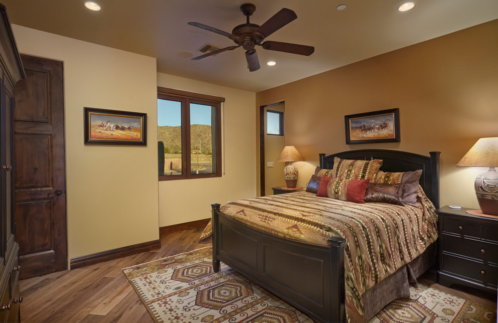 Immagine di una camera degli ospiti american style di medie dimensioni con pareti beige, pavimento in legno massello medio e nessun camino