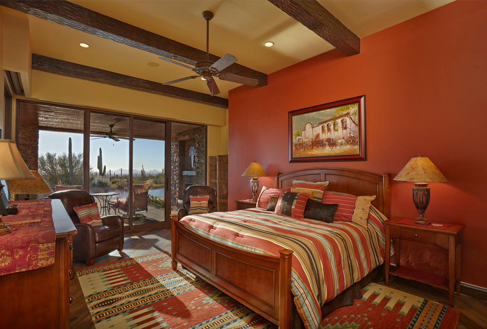 Example of a mid-sized southwest master medium tone wood floor bedroom design in Phoenix with red walls and no fireplace