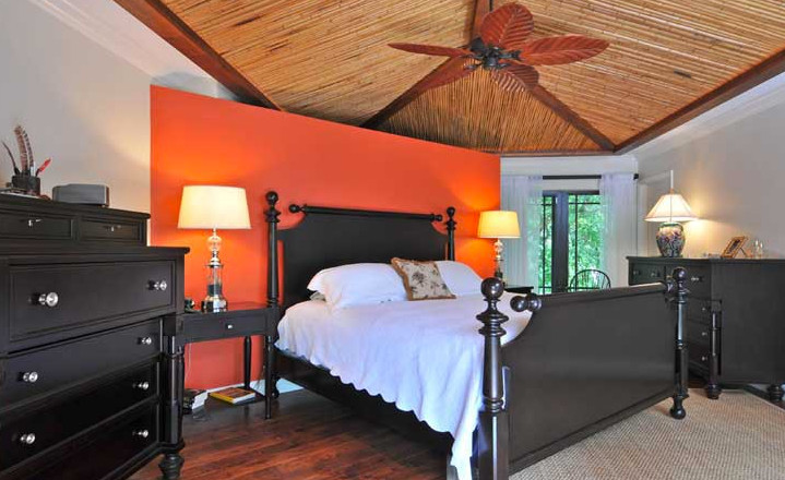 Свежая идея для дизайна: хозяйская спальня среднего размера в стиле модернизм с оранжевыми стенами, темным паркетным полом и коричневым полом без камина - отличное фото интерьера