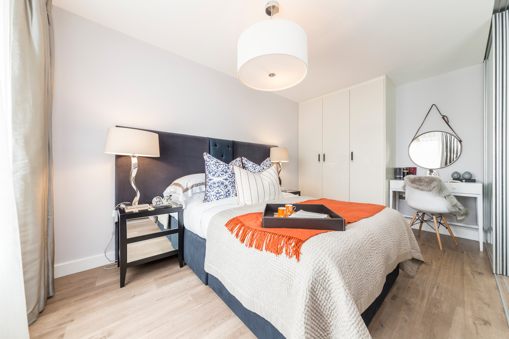 Mittelgroßes Modernes Schlafzimmer mit grauer Wandfarbe und braunem Boden in London