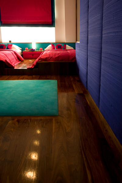 Modelo de habitación de invitados tradicional de tamaño medio con paredes blancas y suelo de madera en tonos medios