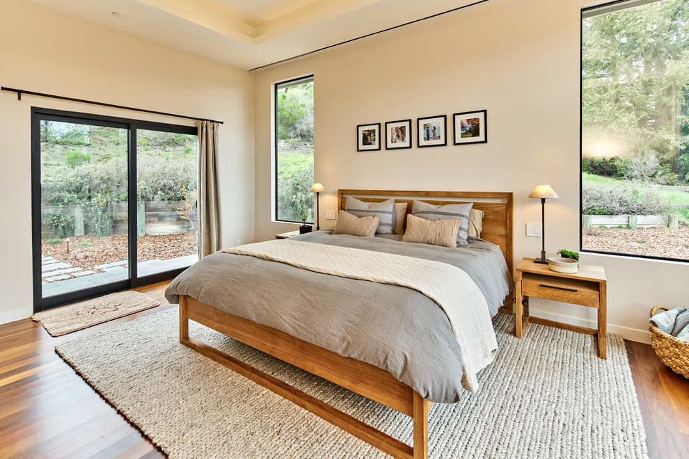 Diseño de dormitorio contemporáneo con paredes beige, suelo de madera oscura y suelo marrón