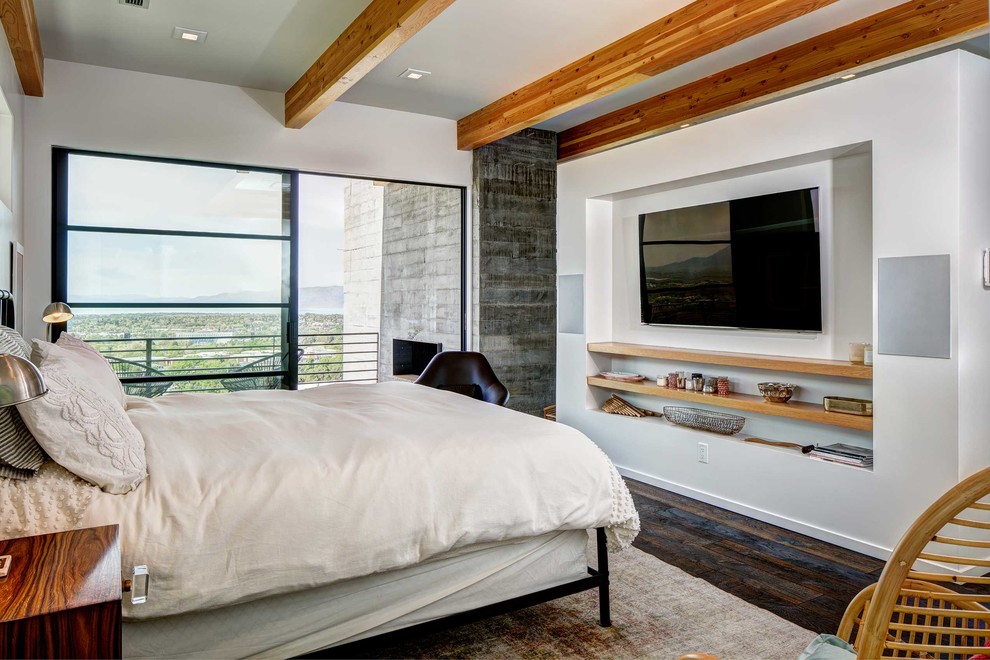 На фото: хозяйская спальня в современном стиле с белыми стенами, темным паркетным полом, коричневым полом и телевизором без камина
