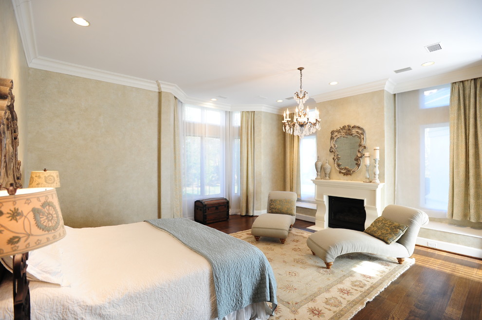 На фото: большая хозяйская спальня в классическом стиле с бежевыми стенами и темным паркетным полом с