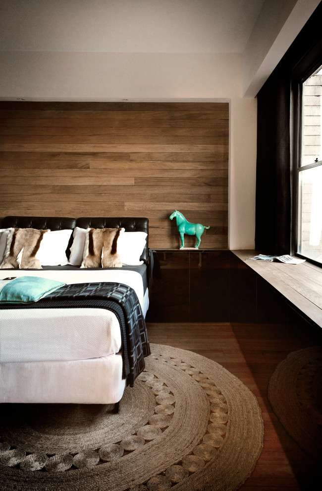 Example of a mid-sized trendy medium tone wood floor bedroom design in Sydney with gray walls