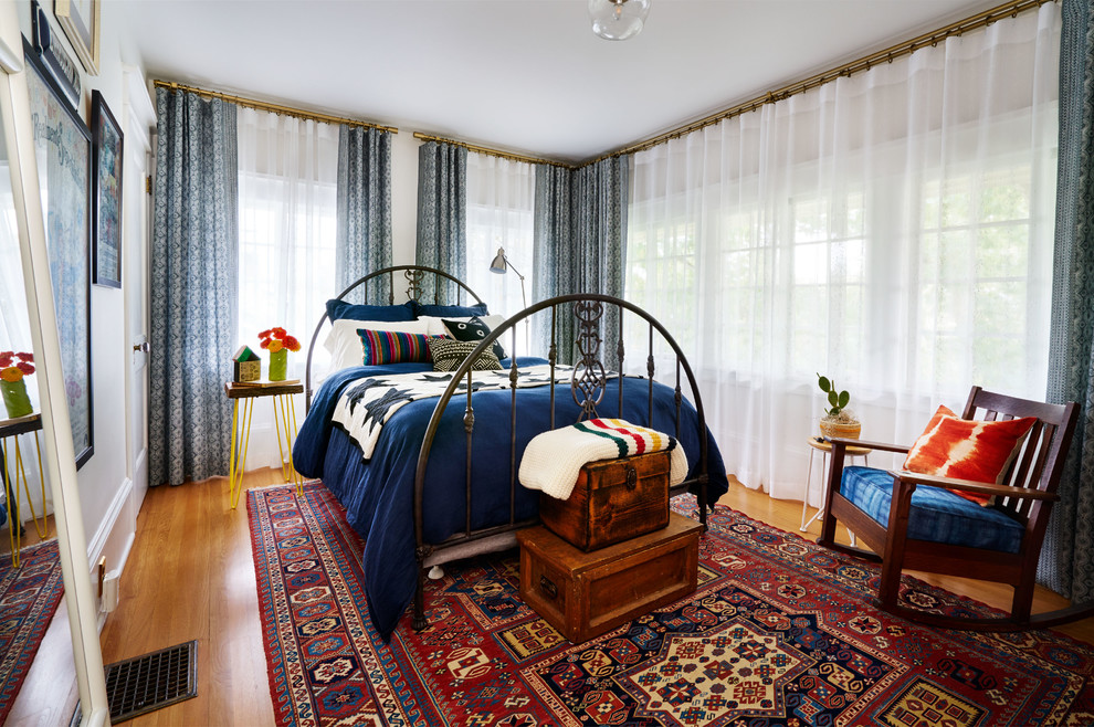 Foto de habitación de invitados bohemia de tamaño medio con paredes blancas, suelo de madera en tonos medios y suelo marrón