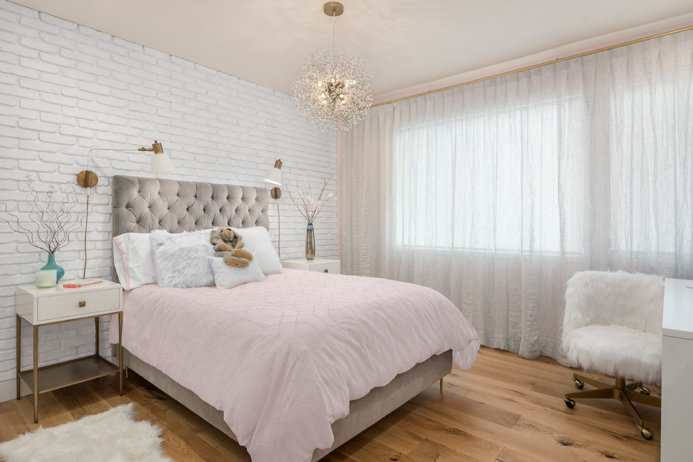 Réalisation d'une petite chambre design avec un mur rose, parquet clair et un sol marron.