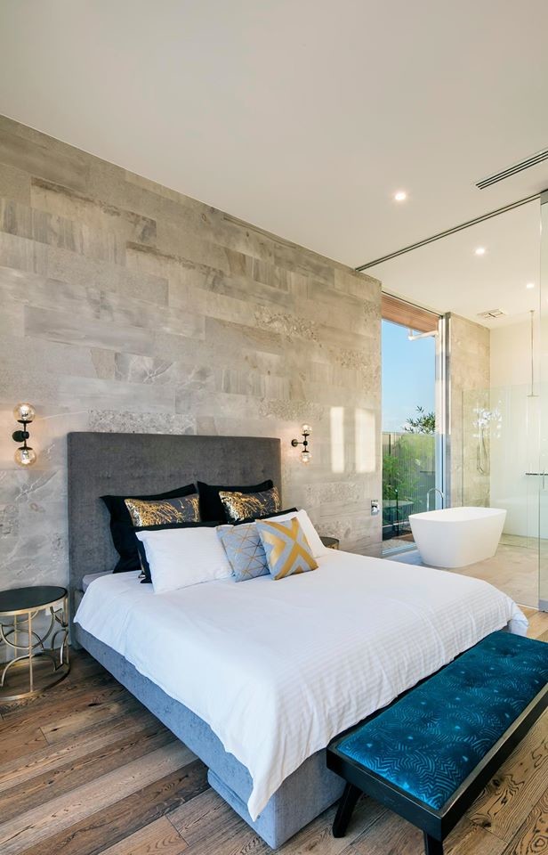 Photo of a large modern master bedroom in Adelaide with grey walls, medium hardwood flooring and brown floors.