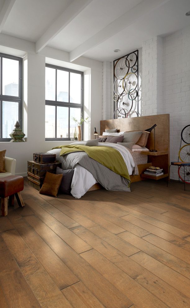 Inspiration för ett industriellt sovrum, med ljust trägolv och brunt golv