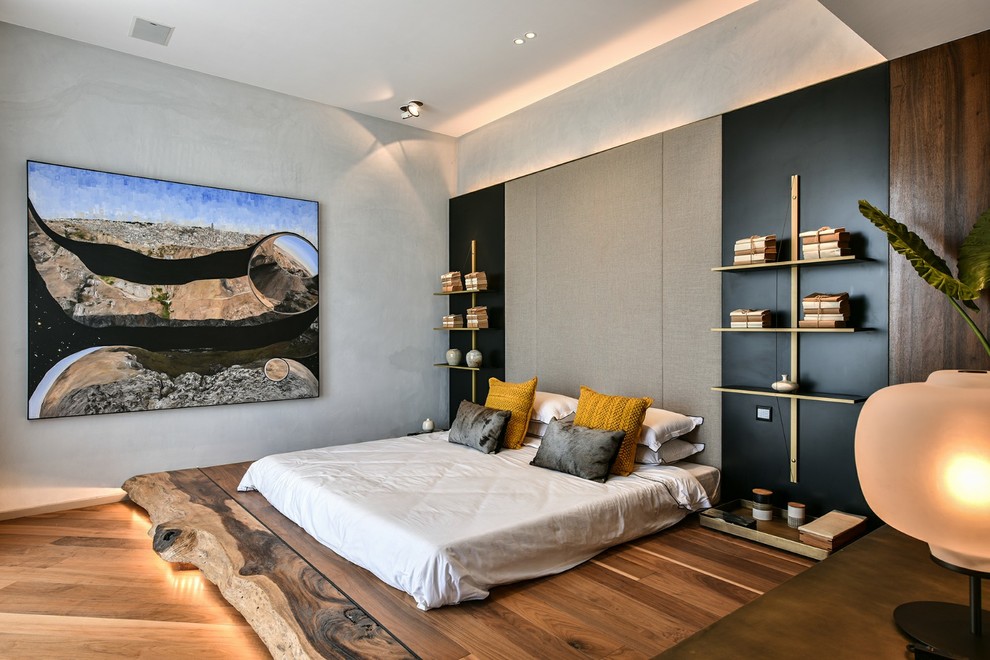 Idee per una camera da letto design di medie dimensioni con pareti grigie, pavimento in legno massello medio e pavimento marrone
