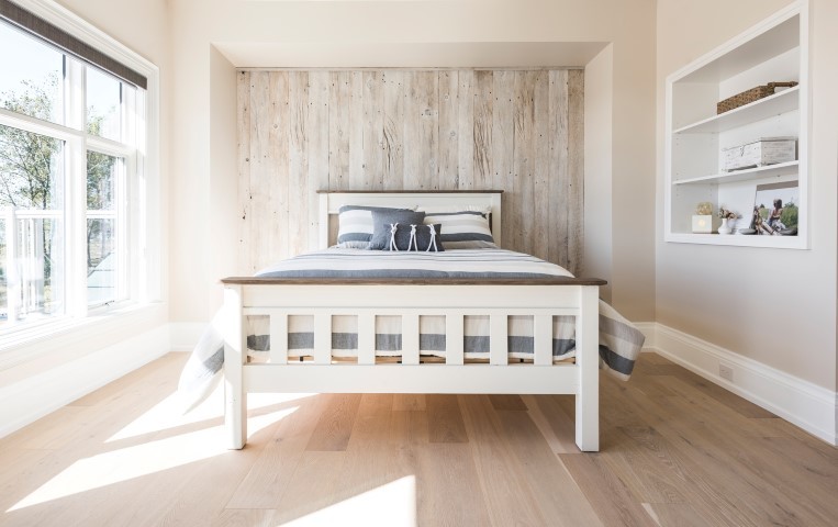 Modelo de habitación de invitados campestre de tamaño medio sin chimenea con paredes beige, suelo de madera clara y suelo beige