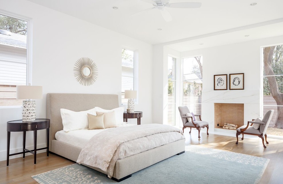 Inspiration for a large transitional master light wood floor bedroom remodel in Dallas with a standard fireplace, a tile fireplace and white walls