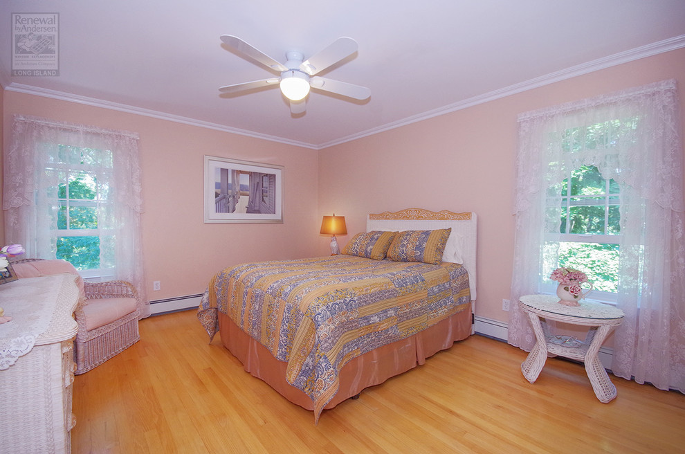 Diseño de dormitorio principal grande con paredes beige, suelo de madera clara y suelo marrón