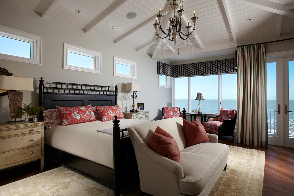 Foto de dormitorio tropical con paredes grises y suelo de madera oscura