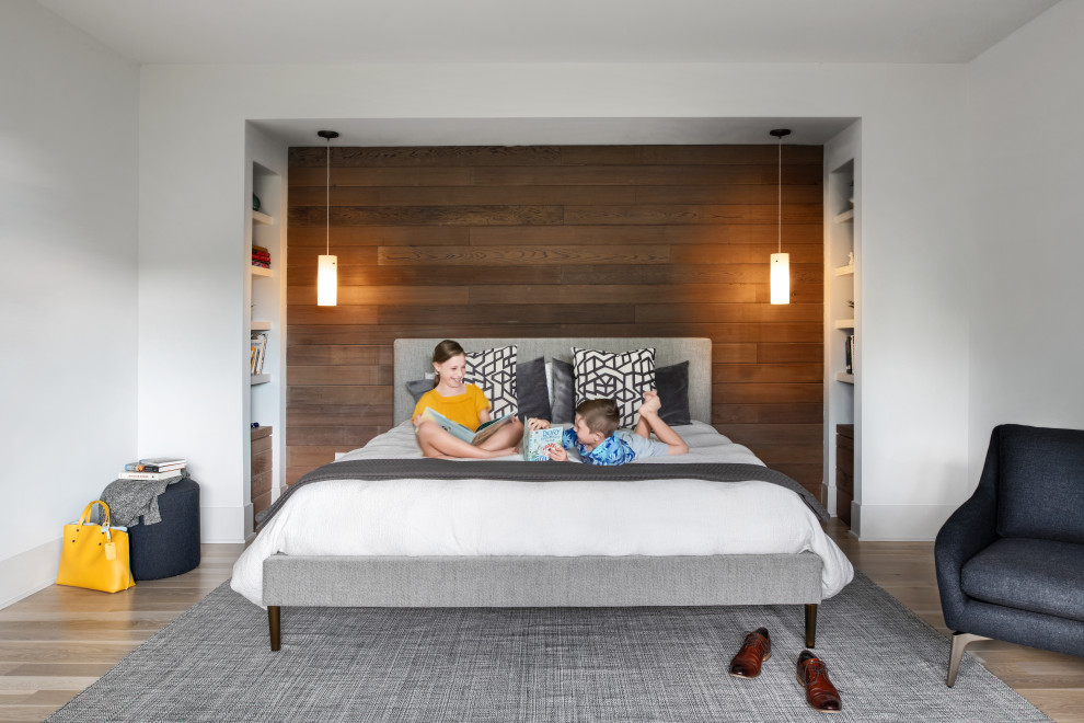 Mittelgroßes Modernes Hauptschlafzimmer mit weißer Wandfarbe, hellem Holzboden, grauem Boden und Holzwänden in Houston