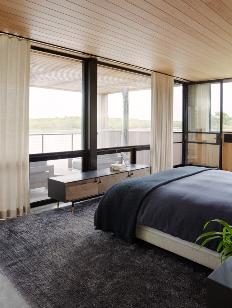 Großes Maritimes Hauptschlafzimmer mit brauner Wandfarbe, Betonboden, grauem Boden und Holzwänden in New York