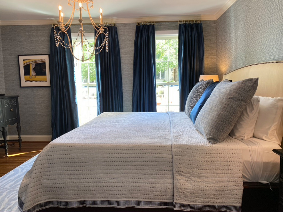 Example of a small master medium tone wood floor and wallpaper bedroom design in Raleigh with blue walls
