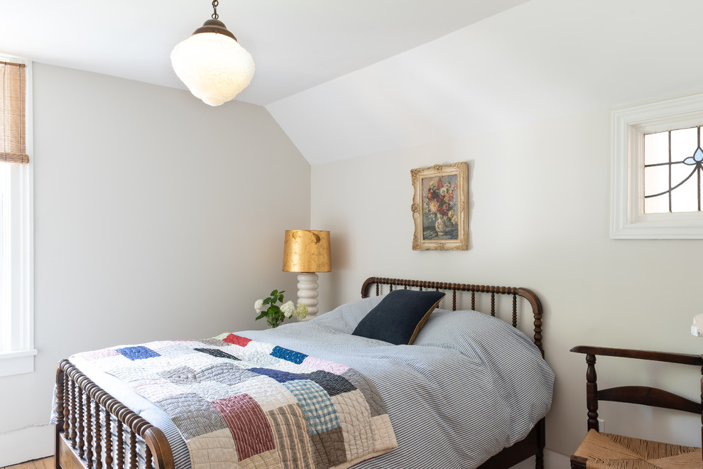 Cette photo montre une chambre d'amis victorienne avec un mur blanc, un sol en bois brun, aucune cheminée et un sol marron.