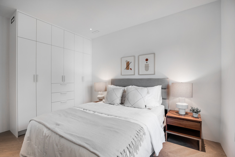 Aménagement d'une chambre parentale contemporaine de taille moyenne avec un mur blanc, parquet clair et un sol beige.